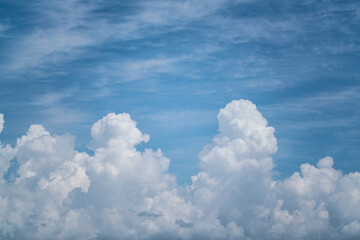 Fluffy White Clouds Against a Bright Blue Sky with Soft Wispy Atmosphere
