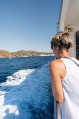Tourist observing the coastline from a boat trip around cadaques, on the coast of girona, spain