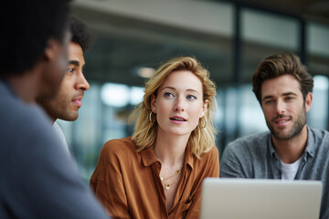 Diverse young professionals collaborating and discussing ideas in a modern office environment