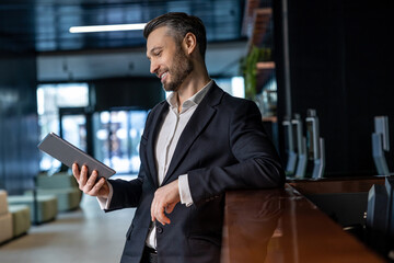 Man reading something online on a tablet and looking interested