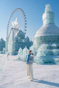 Young happy female tourist enjoying at ice and snow world festival in Harbin, China