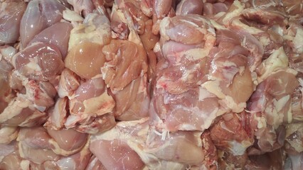 Close-up of fresh raw chicken fillet pieces displayed at a market or store, showcasing uncooked poultry meat with natural texture, color, and detail for food industry use