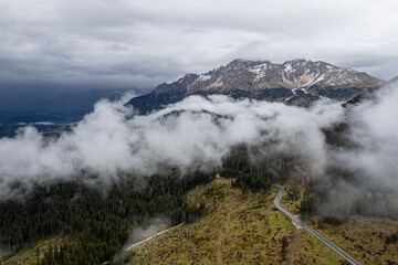 Foggy Dolomites mountain landscape with cloudy dramatic sky in Italy.