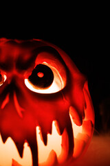 Frightening Halloween pumpkin with smoke escaping from mouth, glowing eyes and face in the dark.