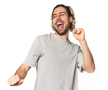 Young Caucasian man in studio setting dancing and having fun. - Powered by Adobe