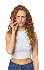 Simple redhead studio portrait celebrating a special day, jumps and raise arms with energy.