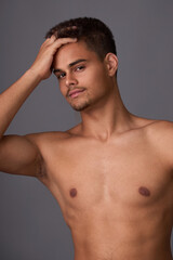 Portrait of attractive muscular young brunette sportsman with short haircut and light stubble on...