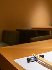 A cozy fine dining table set with chopsticks, hashioki and a simple mulberry paper placemat,...