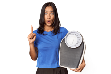 Filipino woman with scale in studio having some great idea, concept of creativity.