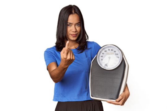 Filipino woman with scale in studio pointing with finger at you as if inviting come closer.