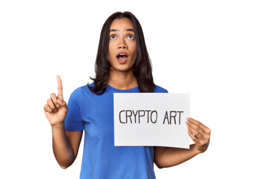 Woman with "crypto art" sign in studio pointing upside with opened mouth.