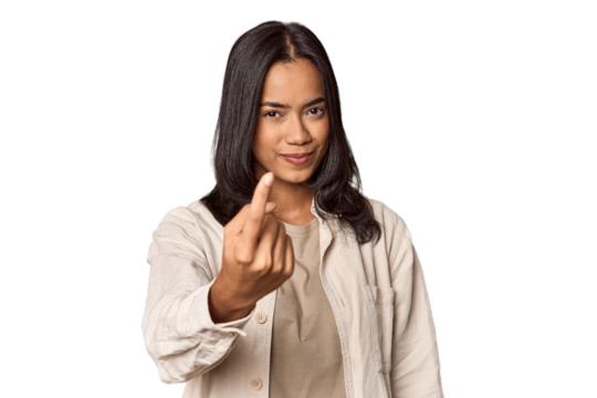 Portrait of a young Filipino woman pointing with finger at you as if inviting come closer.