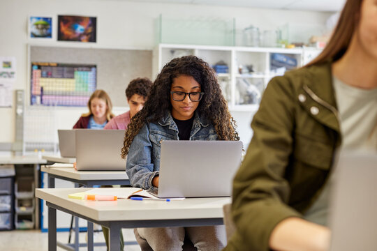 High school students using laptop during computer class