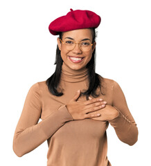 Young Filipina with Parisian look has friendly expression, pressing palm to chest. Love concept.