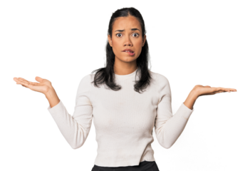 Young Filipina woman confused and doubtful shrugging shoulders to hold a copy space.