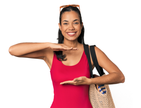 Young Filipina with beach bag holding something with both hands, product presentation.