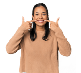 Young Filipina woman smiles, pointing fingers at mouth.