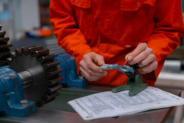 Technician using precision measuring instruments on metal component for quality assurance