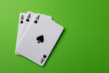 Three aces of spades on a lime green background
