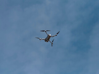 White drone flying against clear blue sky demonstrating aerial capabilities