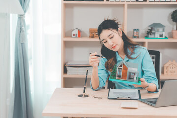 House selling ideas, online consultation with Asian women Real estate concept with wooden house...
