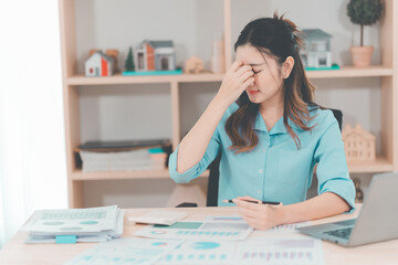 Asian businesswoman dealing with stress and headache feels depressed from low sales, bad economy,...