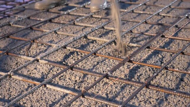 Concrete being poured onto rebar foundation at construction site