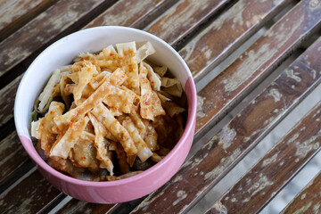 high angle photo from a close distance of a bowl of wonton skin or flour chips sprinkled with...