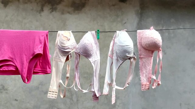 Women's underwear is dried outdoors on a clothesline, under the scorching sun.