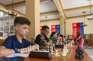 Children engaged in a simultaneous chess competition
