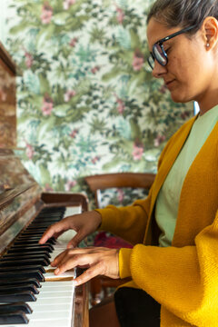 Woman playing piano with focus and passion