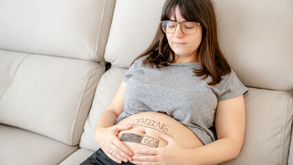 Expectant woman relaxing on a comfortable couch