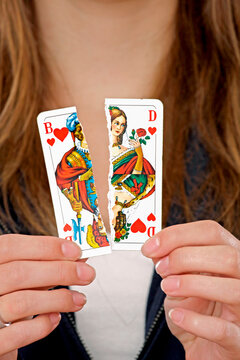 Frau h&auml;lt eine zerissene Spielkarte in Ihrer Hand