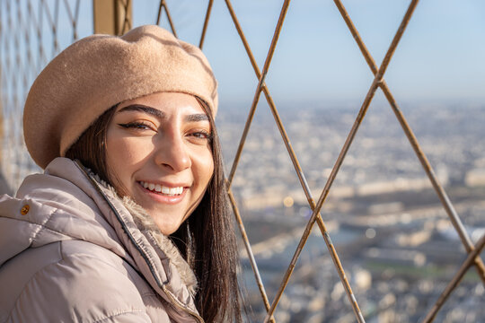 Woman smiling at sunrise on the Eiffel Tower