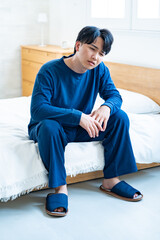 ベッドで項垂れる男性