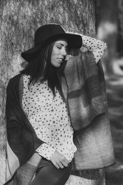 Woman posing in nature wearing a hat and poncho