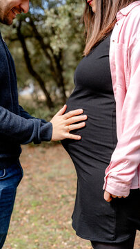 Tender moment between couple with expecting mother outdoors