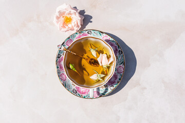 Cup of herbal tea with floral design saucer