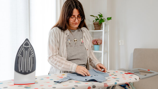 Preparing baby clothes by ironing with care