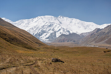 Scenic late summer landscape view of snowcapped Lenin Peak in Trans Alay mountain range near Achik...
