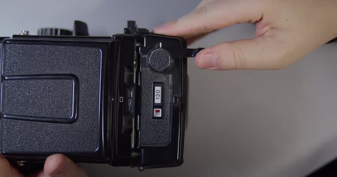 Loading new film in medium format camera.