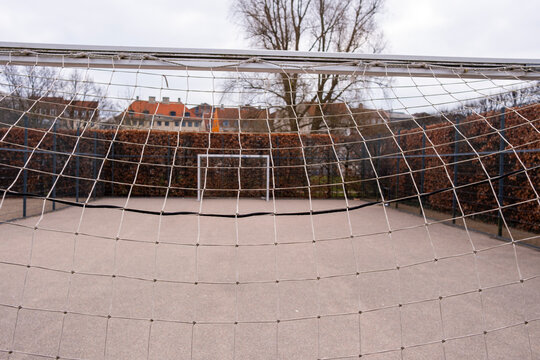 Soccer goal net in outdoor court, representing recreation, community interaction, and minimalist design elements within modern urban contexts and architectural public space compositions.