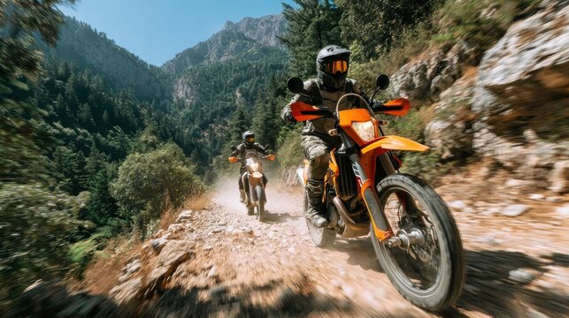 Pair of motorcyclists traversing rocky mountain path beneath clear blue sky