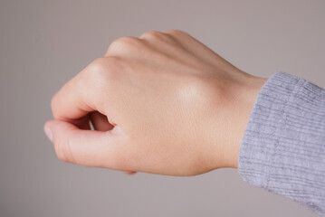 Female right back hand with ganglion cyst on the dorsum,  fluid-filled bump associated with a joint or tendon sheath, close-up view, selected focus.