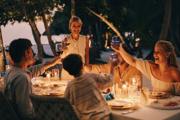 Family toasting at a serene Maldives resort dinner celebration