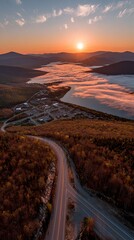 High-angle view of a winding road, meeting point, at sunrise over a valley with a misty river