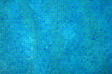 Abstract blue background.  Swimming pool water surface  with blue mosaic tiles.