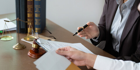 Legal Consultation. Lawyer discussing contract details with a client in an office.
