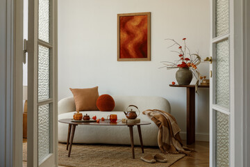 Living room with cream sofa, orange cushion, mock up wall art and wooden coffee table with ceramics...