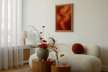 Stylish living room with beige sofa, red mock up artwork, round cushion and large vase with red...